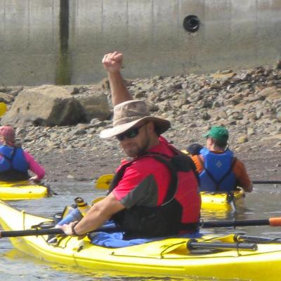 man raising his hand over his head while kayaking
