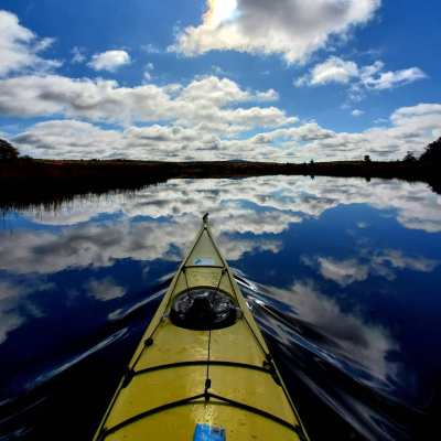 view of body of water looking out over the front of a kayak