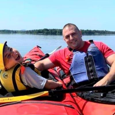 a parent and child in two kayaks smiling at the camera