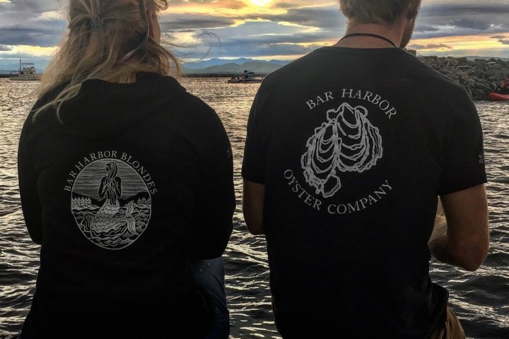 a couple of people that are standing in front of a body of water