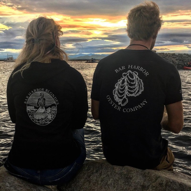 a couple of people that are standing in front of a body of water